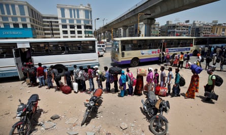 People queue to get on buses to leave the city of Ahmedabad in India as the lockdown is extended.