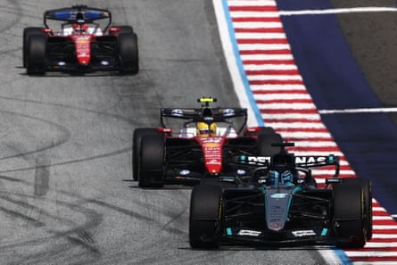 George Russell's Mercedes is followed by Ferrari's Lewis Hamilton and Charles Leclerc on track