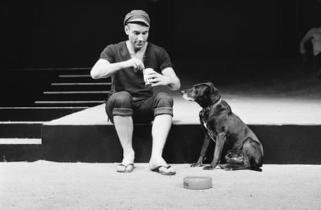 Patrick Stewart, as Launce, sits feeding his dog Crab beside an empty bowl