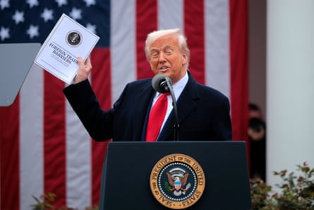 He holds up a copy of a 2025 National Trade Estimate Report
