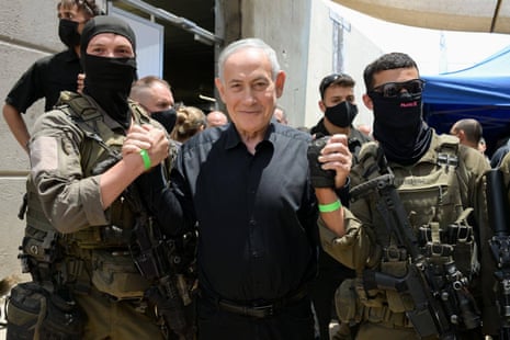 The Israeli PM poses with two soldiers.