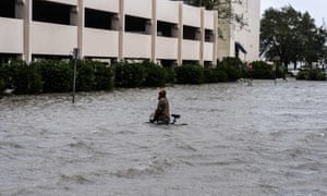 A man walks his bicycle through a street flooded by Hurricane Sally in Pensacola, Florida.