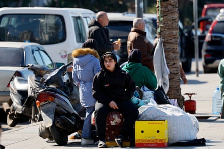 Displaced residents with belongings on a street