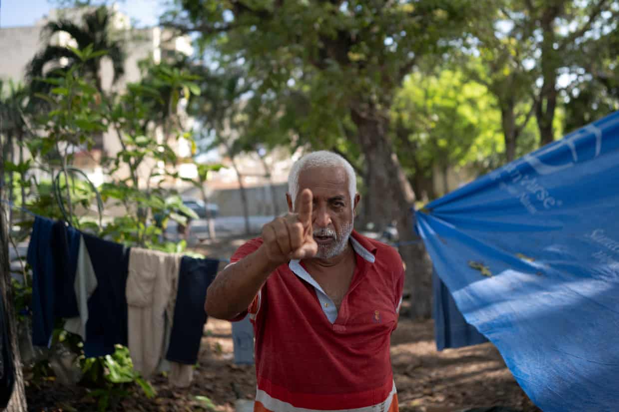 A man in a camp points his index finger