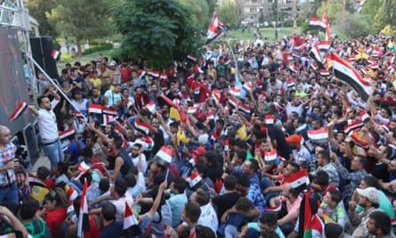 Syrian people celebrate their draw after watching the match on a big screen in a Damascus park.
