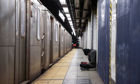 A person sits on the ground in a subway station in Manhattan in February 2022.