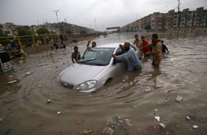 Karachi, PakistanPeople make their way through flood water during heavy rains. Most of the Pakistani cities are experiencing prolonged monsoon season this year