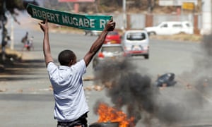 robert mugabe street sign held by protestor