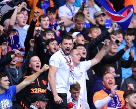 Ross McGill shouting in the stands with other fans at a Rangers match.
