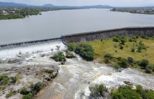 Water flows out of the Centenario dam and over surrounding fields as controlled venting is carried out after heavy rainfall