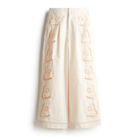 A pair of wide-leg white Broderie anglaise trousers on a white background