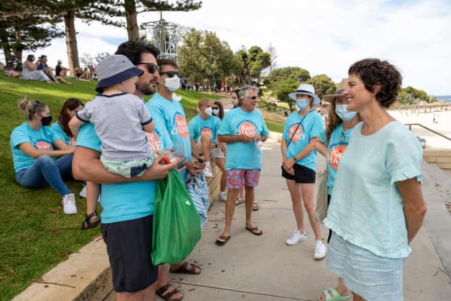Independent Kate Chaney talks to a beachgoer, backed by her volunteers