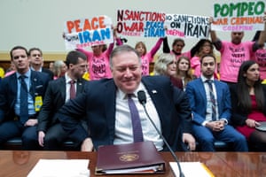 Des manifestants sont vus derrière le secrétaire d'État américain Mike Pompeo lors de son arrivée plus tôt dans la journée pour témoigner devant l'audience de la commission des affaires étrangères de la Chambre sur