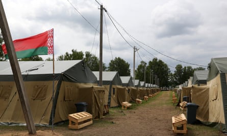 The Belarusian national flag flies above tents at a newly built camp on a site previously used by the Belarusian army, 7 July 2023