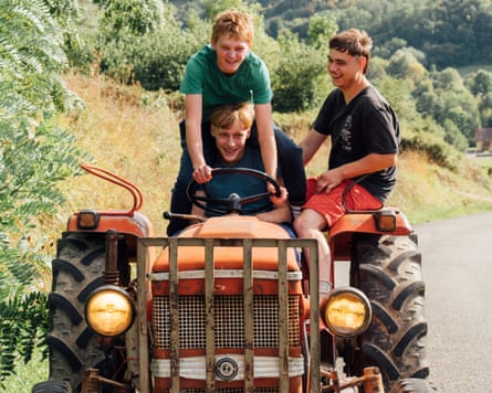 Three children laugh driving a tractor in Holy Cow.