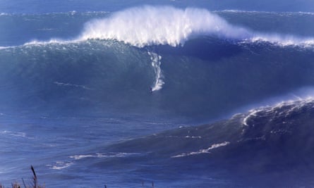 An expert surfer carves a line down one of Nazare’s giant waves.