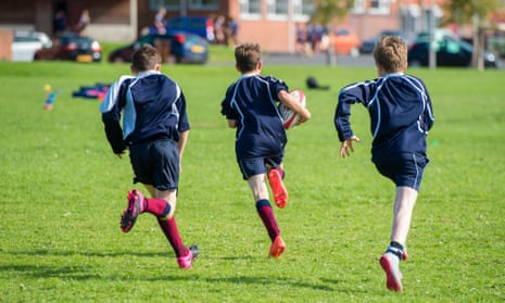 A young boy playing rugby