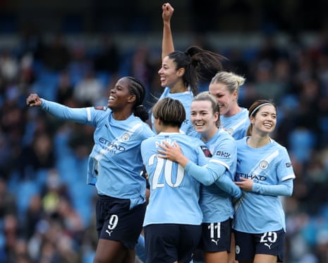Lauren Hemp of Manchester City celebrates scoring her team's third goal with Khadija Shaw, Yui Hasegawa and teammates during the match against Manchester United.