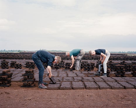 Men cutting turf in a field