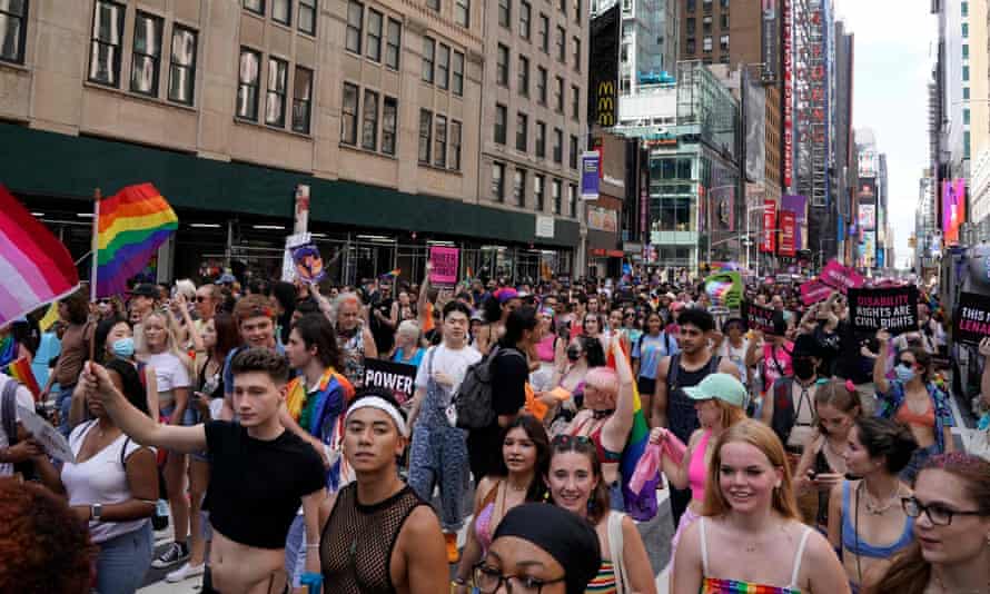 people wearing rainbow colors smile and march