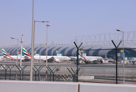 Photo taken from behind the barbed wire fence of planes parked at Dubai international airport