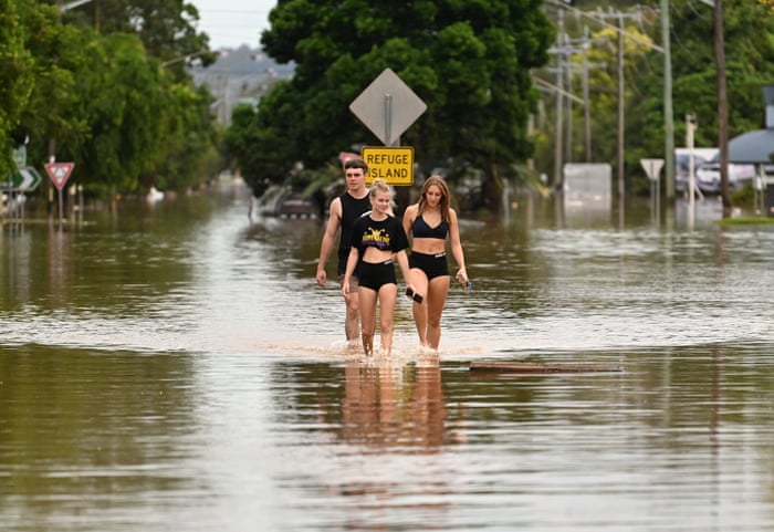 Lismore residents walk through flood water on 31 March.