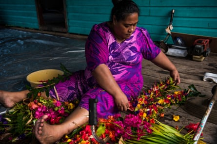 woman makes flower garlands on Kioa