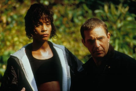 A woman of colour and a white man standing in front of some grass