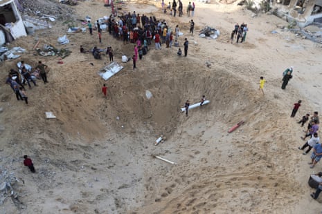 Palestinians gather at the site of a tent camp that was struck by an Israeli airstrike on Friday, in Gaza City.