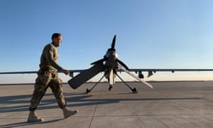 US forces walking past a drone in the Ain al-Asad airbase in the western Iraqi.