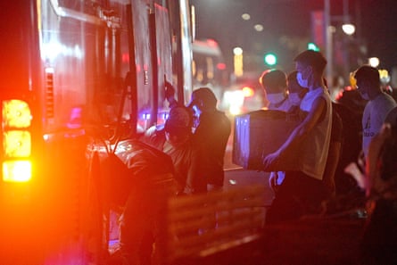 Workers carry their belongings on to a bus as they leave a suspected scam centre compound in Sihanoukville on 14 January 2026.