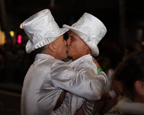 Newly married couple Darren Sheen and Heath Seib have a little kiss at the back of the float as their guests dance up Oxford St.