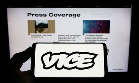  Person holding smartphone with logo of broadcasting company Vice Media LLC on screen in front of website. 