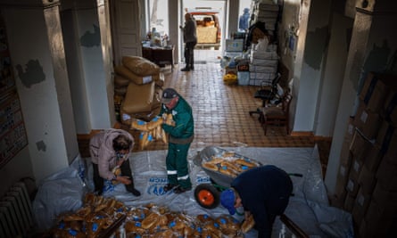Local residents prepare bags of bread to distribute them to people in Siversk, Donetsk region, on 2 May 2023, amid the Russian invasion of Ukraine.