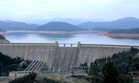Body of water and mountains behind a large, grey dam