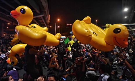 File photo taken on 27 November 2020 shows pro-democracy protesters holding up large inflatable yellow ducks during a rally in Bangkok.