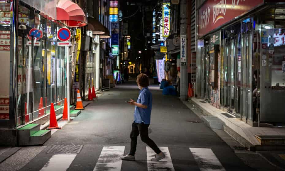 A man looks at an almost empty street in Shimbashi, in Tokyo, Japan.