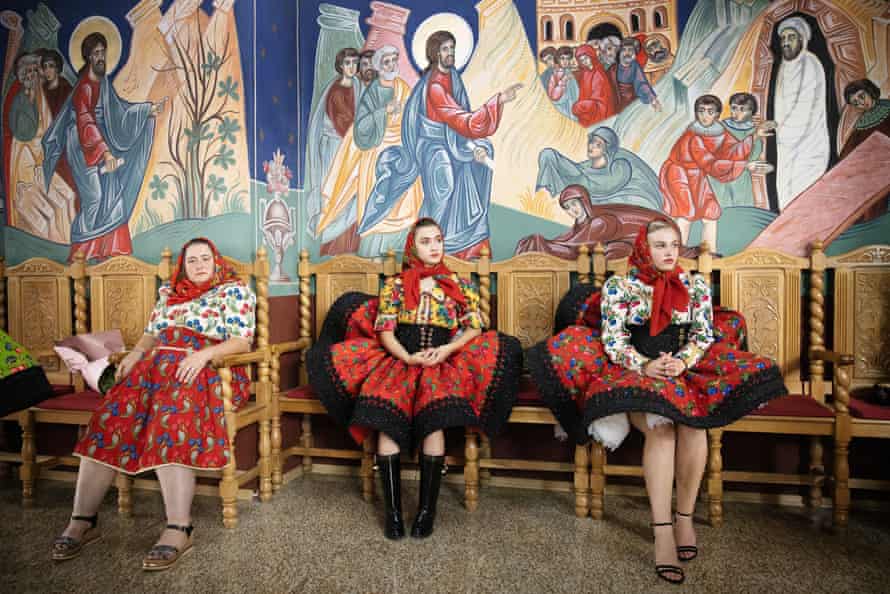 Women in traditional costumes watch a wedding ceremony in a Romanian Orthodox church in the village of Tur.