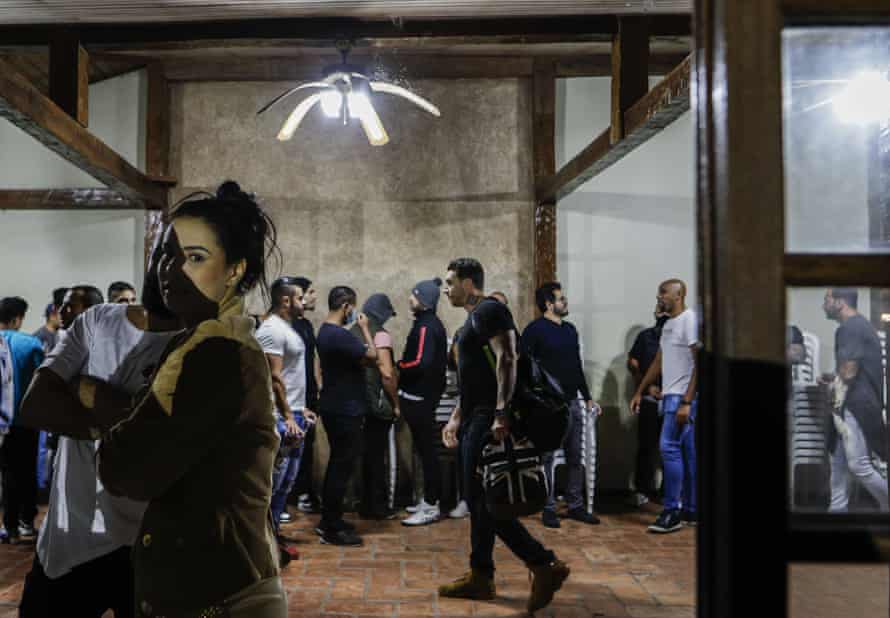 Partygoers at a hall in Sao Paulo, Brazil, wait to have their ID cards photographed by police after the force broke up their social gathering in an operation against illegal and clandestine gatherings.