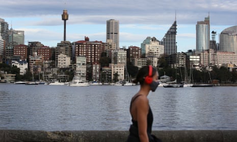 A woman wears a face mask while walking in Sydney’s Rushcutters Bay