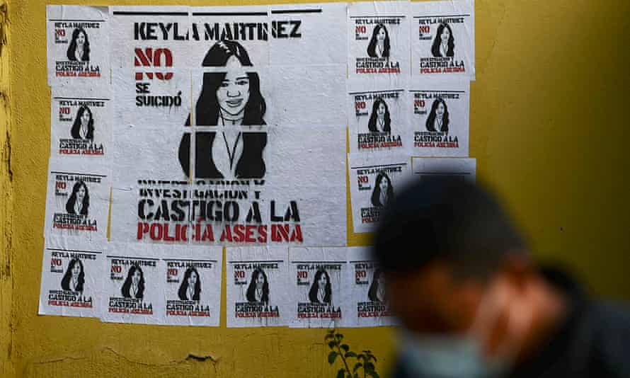 A member of the Honduran national police stands in front of a signal that reads ‘Keyla Martinez didn’t kill herself, investigate and punish the police’, in La Esperanza, Honduras.