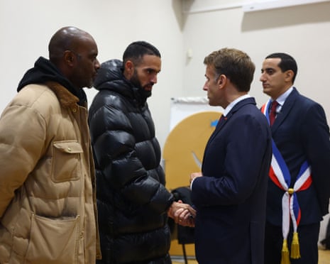 Macron shaking hands with community members in Trappes