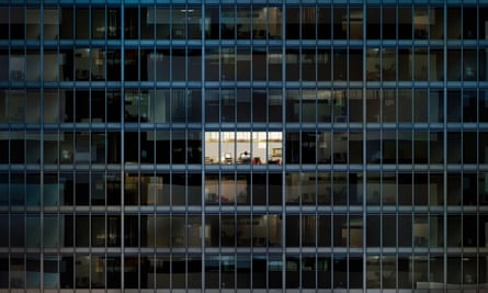 Up all hours: a worker burns the night oil in an empty office block.