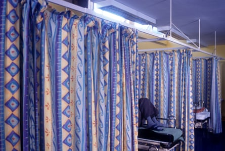 Patients waiting to be treated behind curtains in a hospital ward