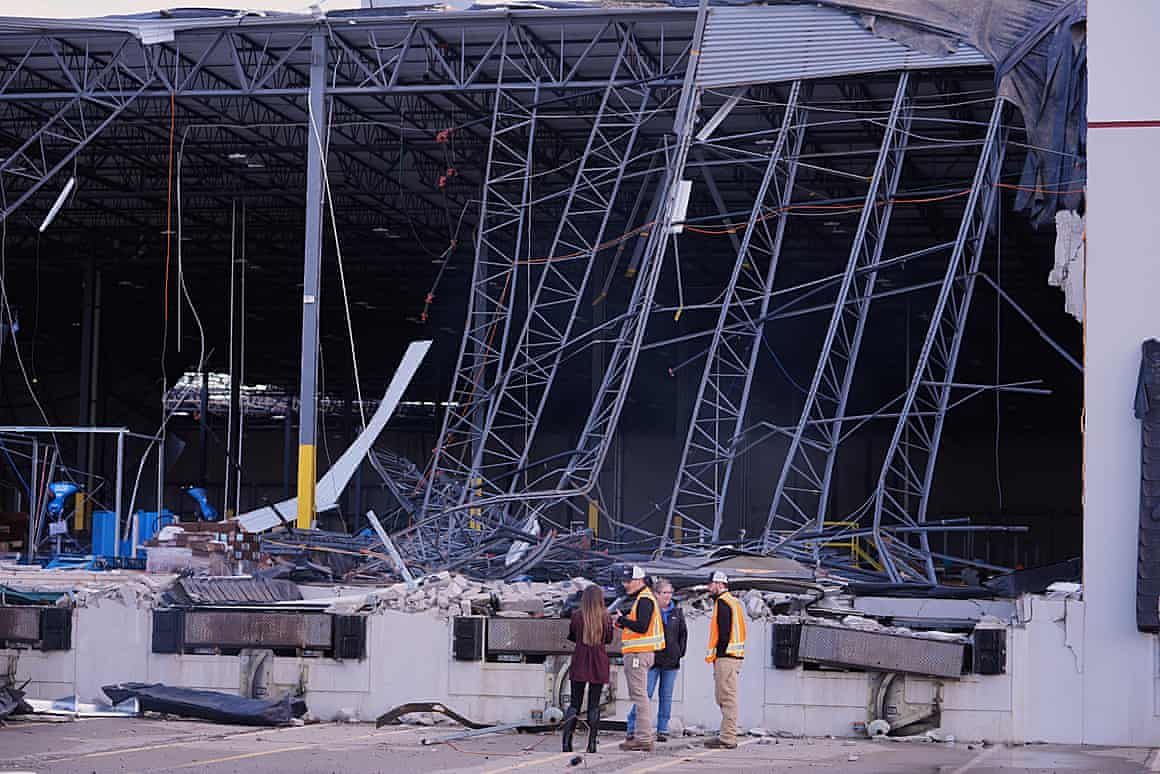 Recovery workers survey storm damage to a warehouse in Brownsburg, Indiana, on Thursday.
