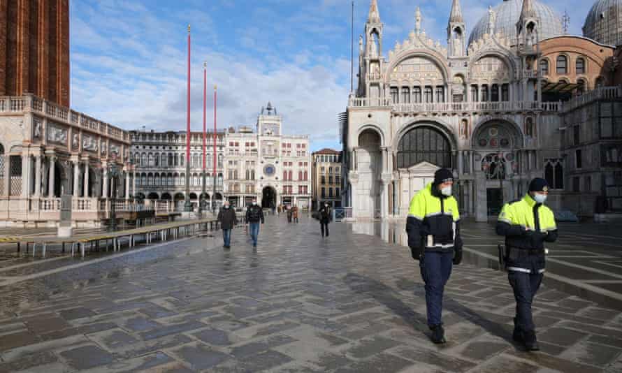 Police officers walk in St. Mark’s square on the day that Venice Carnival was due to begin, with the annual event cancelled due to coronavirus disease precautions, in Venice, Italy, January 31, 2021.