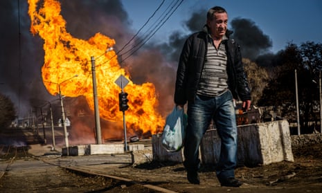 A man hurries to walk away from a building that was just hit by Russian bombardment, and caught on fire, in the Moskovskyi district in Kharkiv, Ukraine, on Friday.