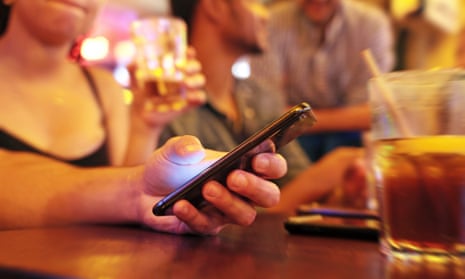 Person with friends using mobile phone in bar