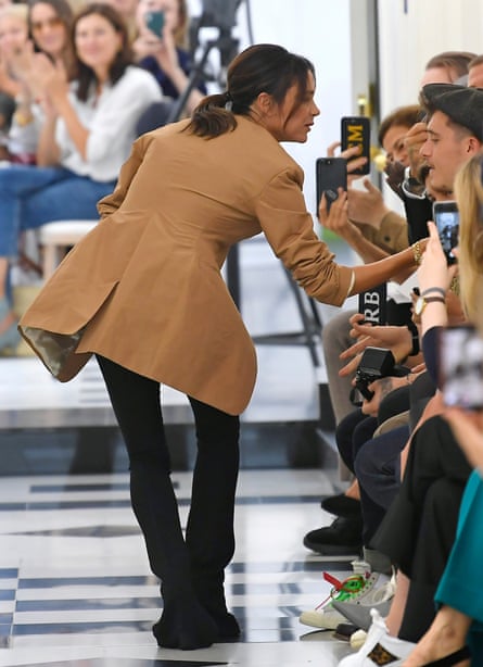 Victoria Beckham on the catwalk at London fashion week in September 2018, talking to son Brooklyn (in cap)