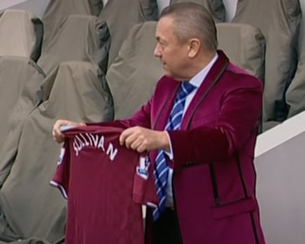 David Sullivan holding a football jersey with his name on it
